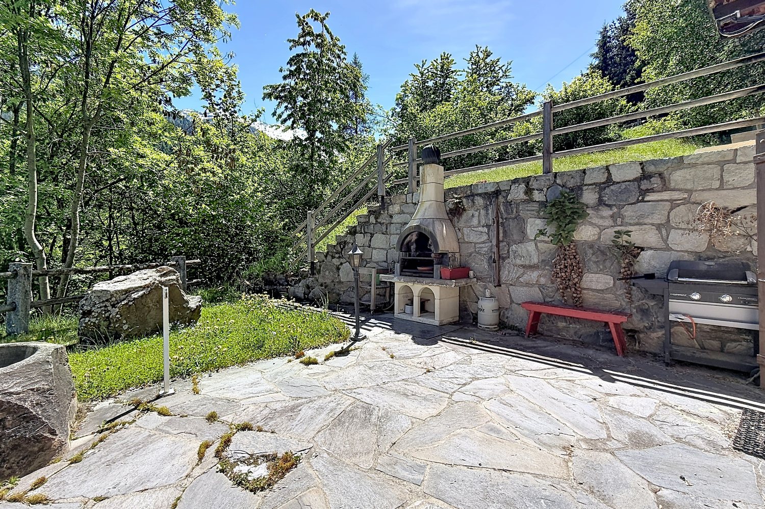 Le jardin privatif avec son barbecue en pierre.